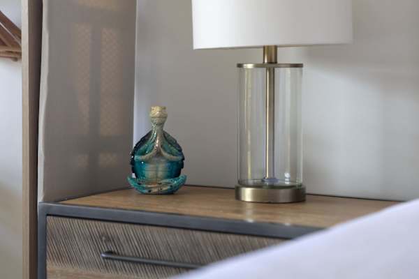 Find your peace with thoughtful, serene bedside touches, including a modern glass table lamp.