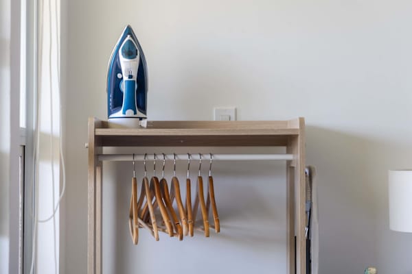 Keep your vacation wardrobe fresh and wrinkle-free with a dedicated clothing rack, wooden hangers, and a steam iron.