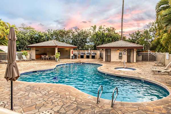 Lounge the day away around the beautiful, inviting pool with its surrounding stone deck, set amidst palm trees and complete with a nearby hot tub and covered BBQ/grill area for the perfect sunny afternoon.
