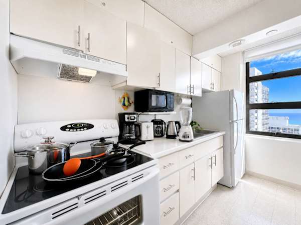 Whip up delicious home-cooked meals in this fully equipped, sunlit kitchen featuring ample counter space and stunning ocean views
