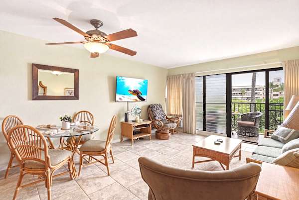 Relax in your light-filled living room featuring tropical-style furnishings, dining area, and direct access to your private covered balcony.
