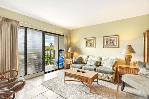 Unwind in your living space styled with tropical charm, a sleeper sofa, and floor-to-ceiling glass doors opening directly to the private balcony.