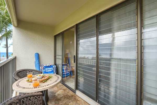 Sip your morning coffee or enjoy an al fresco snack on your private covered balcony, complete with cozy outdoor seating and partial ocean views.