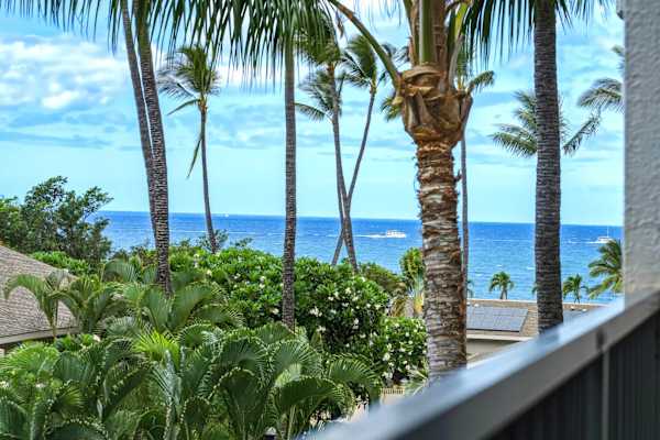 Step out onto your private balcony and soak in breathtaking partial ocean views framed by swaying palm trees and lush tropical greenery.