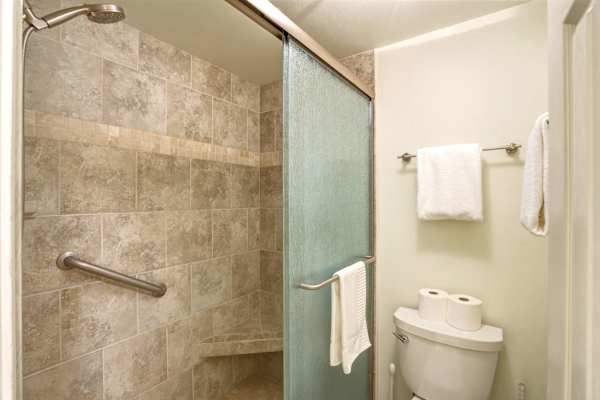 Rinse off after a day at the beach in your walk-in shower, complete with glass doors.