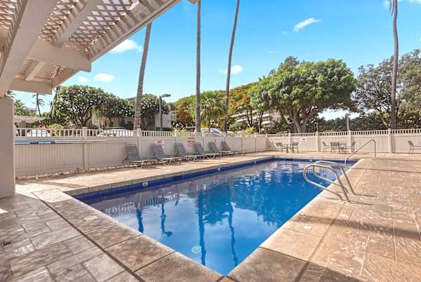 Take a refreshing dip in the sparkling outdoor pool, surrounded by comfortable lounge chairs and lush tropical greenery.