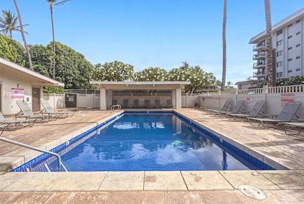 Take a refreshing dip in the sparkling outdoor pool, surrounded by comfortable lounge chairs and lush tropical greenery.