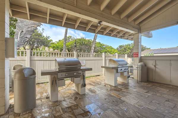 Grill up a delicious meal at the covered outdoor BBQ station, equipped with stainless steel gas grills and surrounded by lush tropical landscaping.