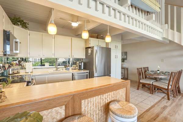 Enjoy cooking and dining in your fully equipped, open-concept kitchen featuring stainless steel appliances, a spacious breakfast bar, and an adjacent dining area.