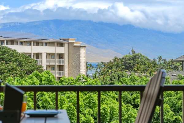 Take in picturesque island views from your lanai, framed by lush tropical greenery, mountain peaks, and a glimpse of the ocean in the distance.