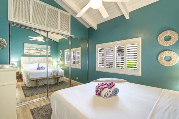 Featuring plantation shutters, high vaulted ceilings, and mirrored closet doors, your primary bedroom offers a cool and airy tropical retreat.
