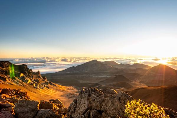 Catch a breathtaking sunrise above the clouds at the summit crater of Haleakalā National Park, offering panoramic views across Maui's volcanic landscape.