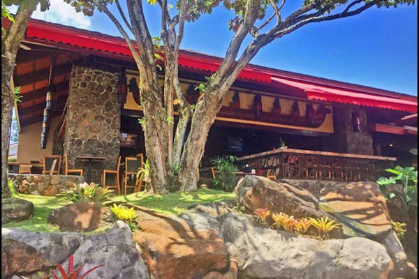 Resort entrance showcases stone architecture, tropical gardens, and welcoming pathwayse