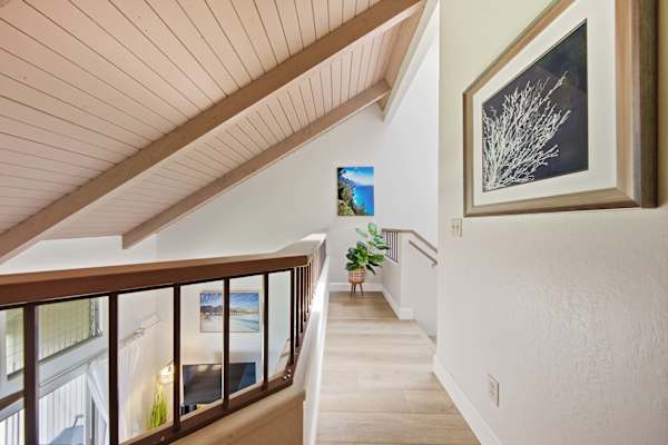 Bright hallway features vaulted ceilings and artwork.