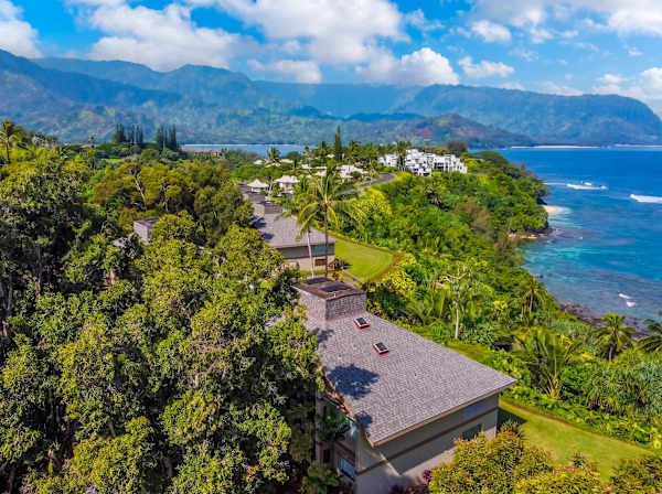Tropical surroundings stretch toward distant hills, gardens, and open skies