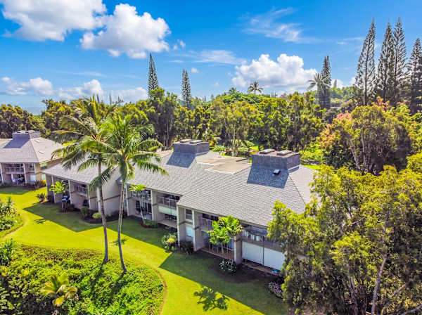 Welcoming home facade features balconies, landscaped borders, and scenic surroundings