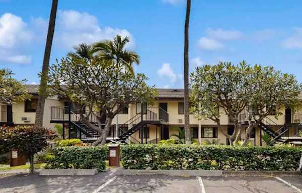Resort exterior with parking and tropical landscaping
