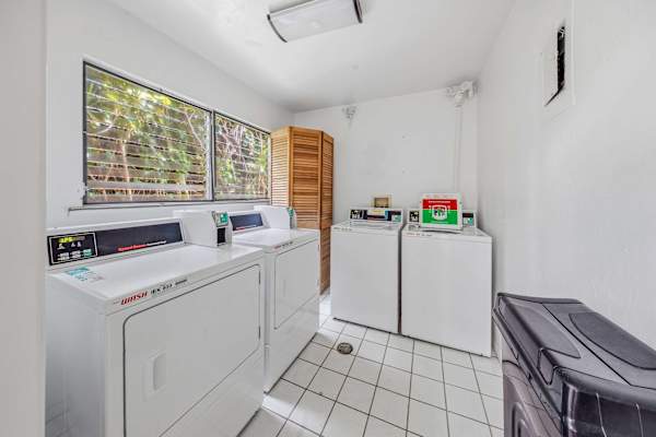 Shared laundry room with multiple washers and dryers