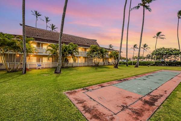 Sunset view of resort pool and lush tropical lawn