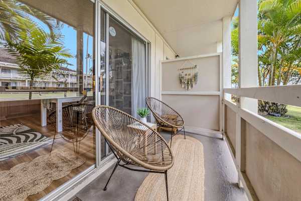 Private lanai with woven chairs, runner rug & privacy divider