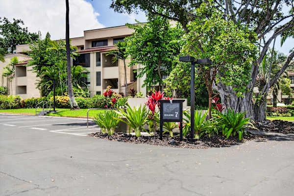 Resort exterior surrounded by lush tropical gardens and parking area