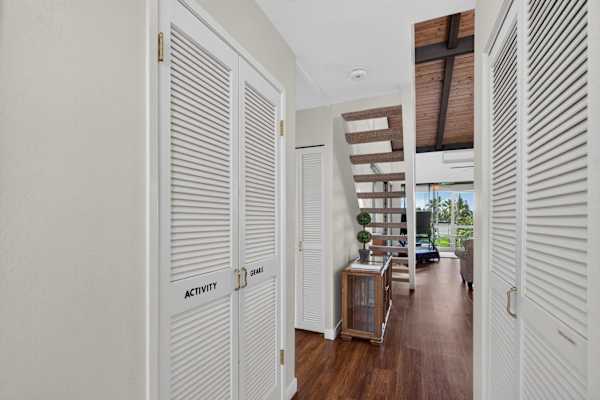 Hallway entrance with built-in storage closets and stairs leading to loft