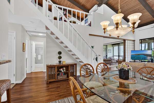 Glass dining table with chandelier and staircase access