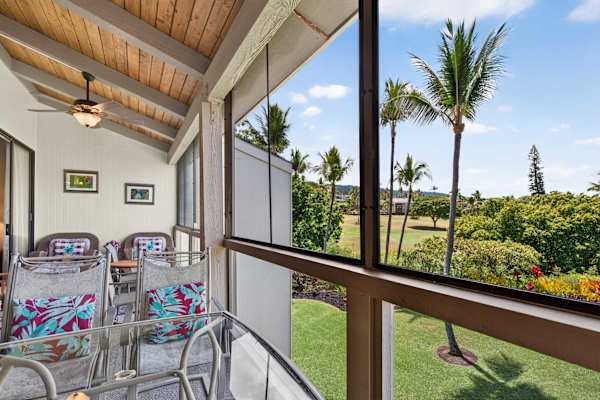 Screened lanai with outdoor seating and lush tropical views