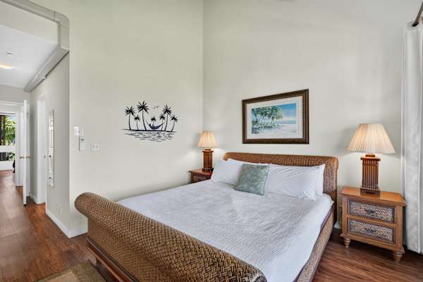 Primary bedroom featuring a king bed with woven frame and bedside lamps