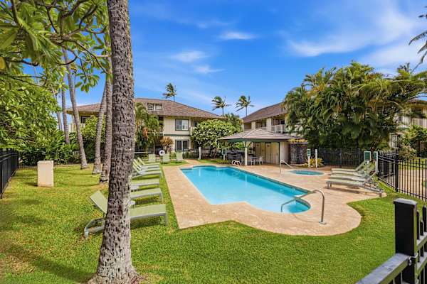Palm-Shaded Pool with Surrounding Buildings and Blue Skies