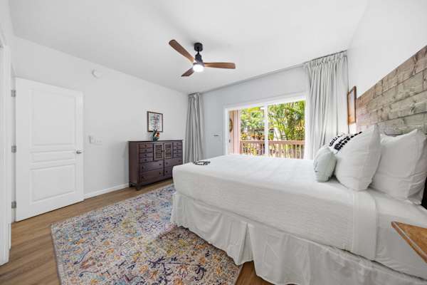 Bedroom with Dresser, Ceiling Fan, and Garden-Facing Window