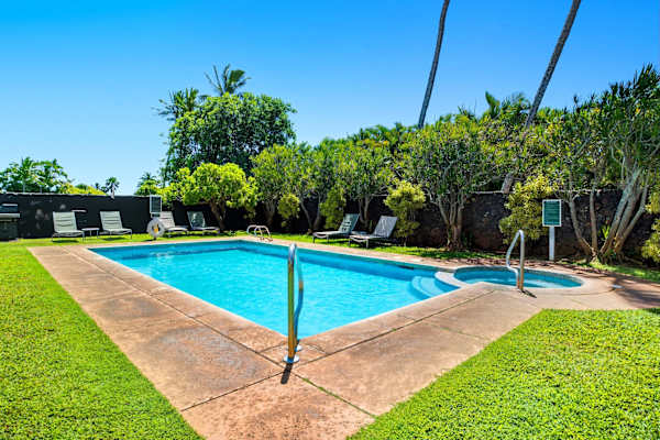 Quiet Pool Area with Green Lawn and Loungers
