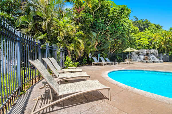 Gated Pool with Loungers and Tropical Garden Backdrop
