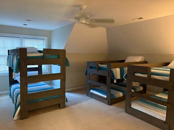 large upstairs bedroom with 3 sets of bunks