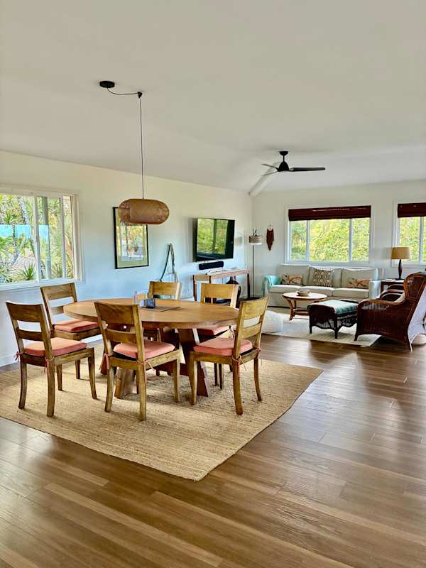 Spacious dining area with wooden table, pendant light & hardwood floors