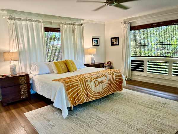 Bright master bedroom with king bed, large windows, and scenic views