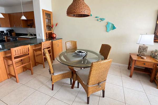Open concept dining with seating for four at the table and two at the breakfast bar