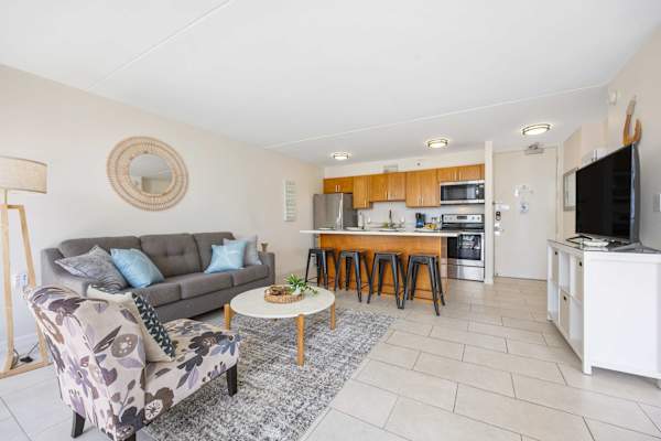 Relax and entertain in style with this bright, open-concept living space seamlessly integrating a cozy lounge area and a fully equipped kitchen with a breakfast bar seating.