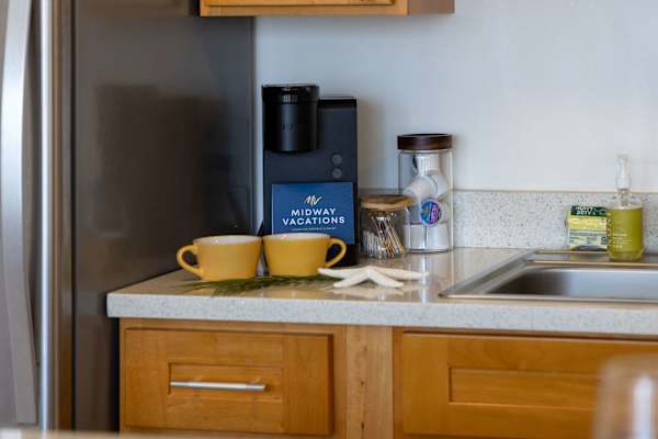 Start your mornings right with a cozy coffee station, complete with a single-serve brewer, mugs, and essential coffee supplies on the countertop.