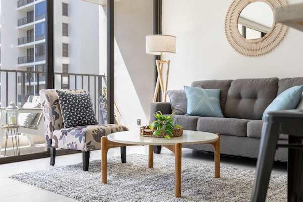 Sink into comfort in this stylishly furnished living room, featuring a sleeper sofa and abundant natural light streaming in from the adjoining balcony.