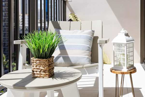 Unwind in style on your private balcony, featuring comfortable outdoor seating, charming accent decor, and plenty of warm sunlight.