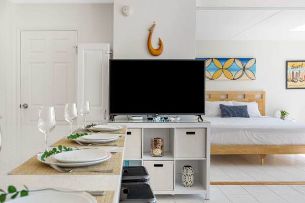 Enjoy effortless dining and entertainment in an open-concept layout featuring an elegantly set dining bar and flat-screen TV.