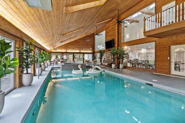 Our heated indoor pool area is an all-season retreat, complete with a nine-person hot tub and surrounded by lush greenery seen through floor-to-ceiling windows.