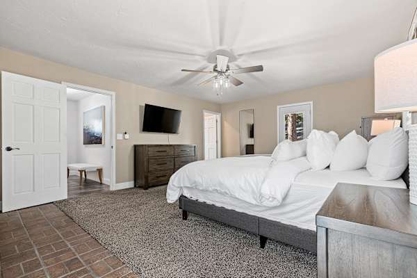 Rest easy in the grandeur of Bedroom #1's king-sized bed, with the serene charm of a non-operational fireplace adding a cozy aesthetic to your peaceful retreat.