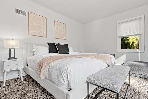 King-sized tranquility in Bedroom #2, where natural light and views of nature welcome you to a new day.