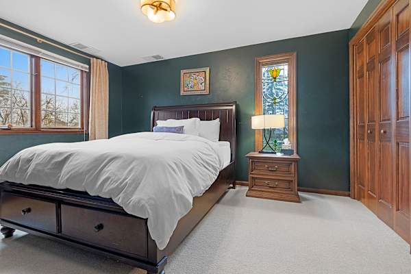 Relax in Bedroom #5's inviting ambiance, a main floor retreat with a queen bed and entertainment at your fingertips, perfect for ease and relaxation.
