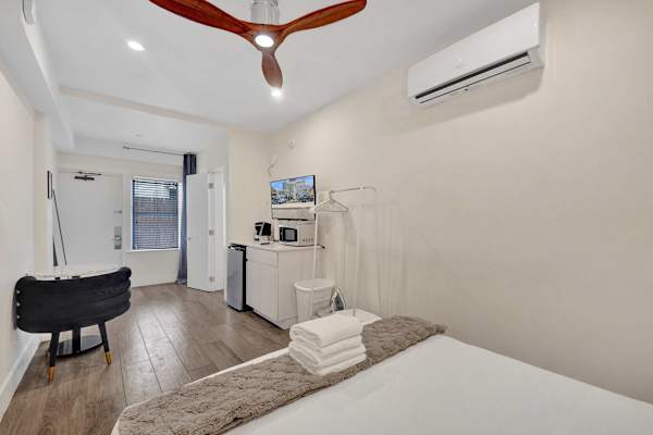 Bright studio room with queen bed and mini-split