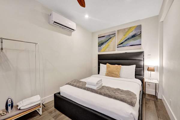 Queen bedroom with mini-split AC and wall art