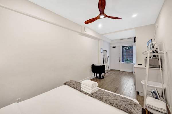 Spacious bedroom with ceiling fan and work desk