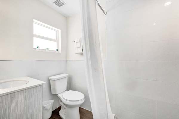 White bathroom with shower and natural light
